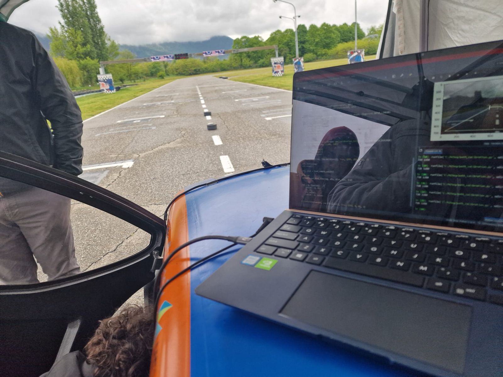 A laptop resting on Juno's blue roof next to the track